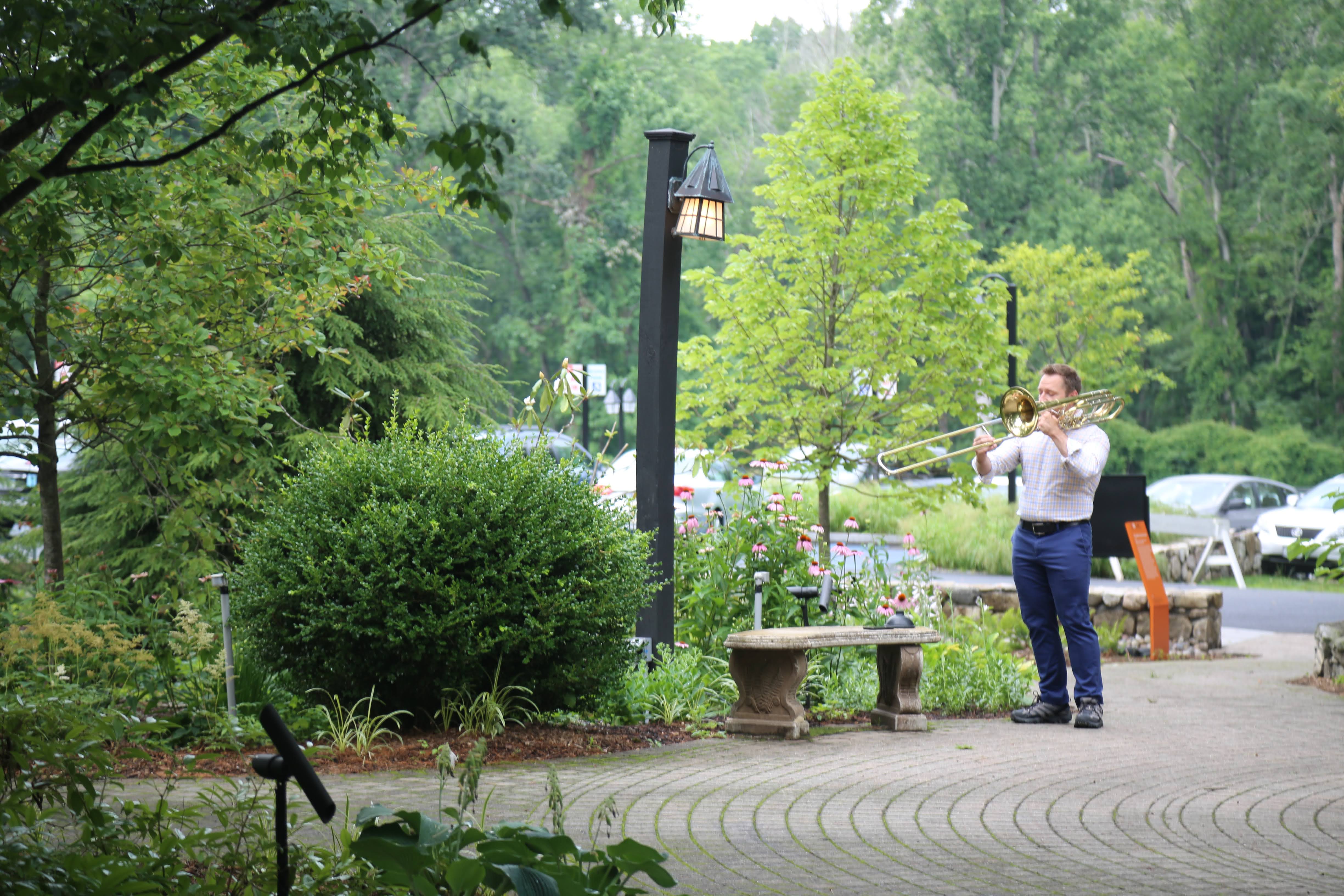 Michael Clayville playing trombone outdoors